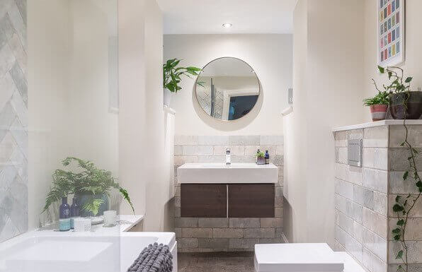 bathroom with circle mirror over sink